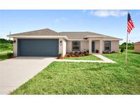 Charming single Gathering home with a well-manicured lawn, blue garage door, and lovely landscaping at 14451 Sw 76Th Avenue Rd, Ocala, FL 34473