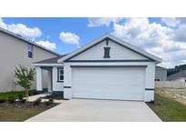 Charming single-story home showcasing a two-car garage, landscaped front yard, and covered entry at 2164 Ne 28Th Ln, Ocala, FL 34470