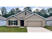 Charming one-story home featuring a two-car garage, neutral stucco exterior, and well-manicured lawn at 2889 Ne 21St Terrace Rd, Ocala, FL 34470