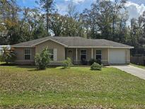 Charming single-story home featuring a well-maintained lawn, attached garage, and inviting entrance at 5520 Nw 57Th St, Ocala, FL 34482
