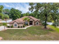 Charming single-story home featuring a well-manicured lawn and beautiful mature trees at 6307 Se 8Th Ln, Ocala, FL 34472