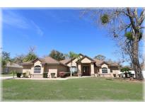 Charming single-story home featuring a well-manicured lawn, mature trees, and a welcoming double-door entrance at 6307 Se 8Th Ln, Ocala, FL 34472