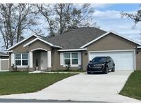 Charming single-story home with a well-manicured lawn, neutral exterior, and attached two-car garage at 1645 Sw 168Th Loop, Ocala, FL 34473