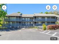 Three-story condominium building with balconies and ample parking on a sunny day at 20800 River Dr # A17, Dunnellon, FL 34431