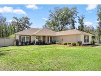 Inviting one-story home features a well-manicured lawn and charming curb appeal with shuttered windows at 530 Nw 113Th Cir, Ocala, FL 34482