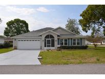 Charming single-story home featuring a two-car garage, screened entry, and manicured lawn at 6548 Sw 84Th Place Rd, Ocala, FL 34476