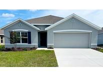 Charming single-story home with a gray exterior, well-manicured lawn, and attached two-car garage at 7137 Se 113Th Ln, Belleview, FL 34420
