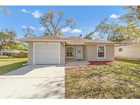 Charming single-story home featuring an attached garage and manicured front yard at 811 Niles St, Daytona Beach, FL 32114