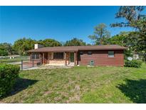 Charming single-story home with brown exterior and well-maintained front lawn on a sunny day at 1505 Ne 33Rd Pl, Ocala, FL 34479