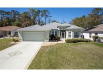Charming single-story home with a well-manicured lawn, lovely landscaping, and a spacious two-car garage at 15304 Sw 15Th Terrace Rd, Ocala, FL 34473