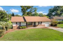 Well-maintained home featuring mature landscaping, a lush lawn, and an inviting curb appeal at 22 Banyan Dr, Ocala, FL 34472
