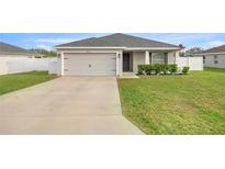 Charming single-story home features a two-car garage, manicured lawn, and front garden at 5537 Se 91St Pl, Ocala, FL 34480