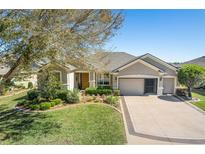 Inviting single-story home boasts a well-manicured lawn and a convenient three-car garage at 6865 Sw 97Th Terrace Rd, Ocala, FL 34481