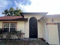 Charming home featuring an arched, security enhanced front entry door and well maintained landscaping at 10 Hickory Loop, Ocala, FL 34472