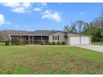 Charming single-story home with a screened porch and a two-car garage at 5615 Se 113Th Pl, Belleview, FL 34420