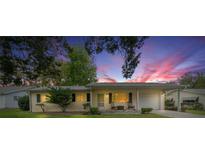 Charming single-story home with a well-maintained lawn, and two rocking chairs on the front porch during a vibrant sunset at 6385 Sw 61St Ct, Ocala, FL 34474