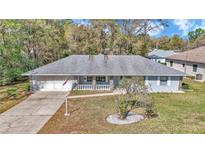 Charming single-story home featuring a well-maintained front yard and attached two-car garage at 9844 Sw 198Th Cir, Dunnellon, FL 34432