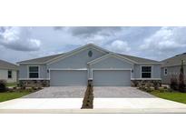 Charming gray home with an attached two-car garage and brick paver driveway at 4755 Nw 39Th Street Rd, Ocala, FL 34482