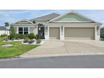 Charming single-story home with a two-car garage and beautifully landscaped front yard with white rock at 5766 Henry Loop, The Villages, FL 32163