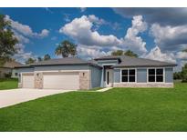 Beautiful single Gathering home featuring a stone accent, well maintained lawn, and neutral blue paint at 9975 Sw 39Th Ter, Ocala, FL 34476