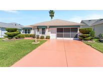 Charming single-story home features a well-manicured lawn and a painted driveway at 1913 Augustine Dr, The Villages, FL 32159