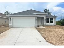 Charming single-story home with a two-car garage, gray facade, and well-manicured lawn at 4365 Sw 90Th Pl, Ocala, FL 34476