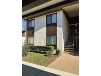 Two-story condo unit with brown trim, sidewalk, and garden bed with green bushes at 532 Bahia Cir # B, Ocala, FL 34472