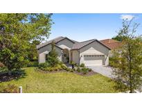 Beautiful single-story home featuring manicured landscaping, a paver driveway, and a two-car garage at 9307 San Jose Blvd, Howey In The Hills, FL 34737