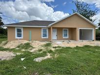 New construction home with light tan exterior, white trim, and attached single car garage at 2147 Sw 3Rd St, Ocala, FL 34471