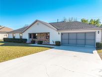 Charming single-story home featuring a brick facade, well-maintained lawn, and a spacious two-car garage at 3275 Nw 44Th Ct, Ocala, FL 34482