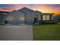 Charming single-Gathering home with a well-manicured lawn and a three-car garage at sunset at 5048 Sw 57Th Pl, Ocala, FL 34474