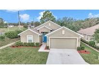 Charming single-story home featuring a blue front door, manicured lawn, and a two-car garage at 6 Diamond Cove Ct, Ocala, FL 34472
