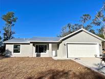 Charming single-story home featuring a new metal roof, attached garage, and neatly staged front yard at 10 Sequoia Trail Ter, Ocklawaha, FL 32179