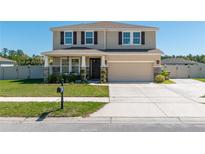 Two-story home featuring a two-car garage, covered front porch, neutral color palette and well-maintained landscaping at 1861 Ne 50Th Ter, Ocala, FL 34470