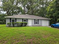 Charming single-story home with a well-manicured front yard and attached garage at 20992 Sw Marine Blvd, Dunnellon, FL 34431