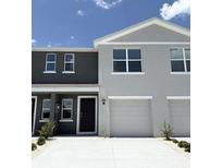 Charming two-story townhome with attached garage and neutral-colored exterior, set beneath a clear sky at 3282 Bertram Rd, Wildwood, FL 34785
