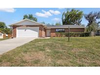 Charming brick home features an attached two-car garage and well-maintained front lawn at 4541 Sw 44Th Ln, Ocala, FL 34474