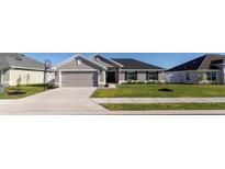 Charming single-story home features a two-car garage and a well-maintained lawn, enhancing its curb appeal at 5001 Sw 91St Pl, Ocala, FL 34476