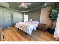 Bedroom featuring a ceiling fan, wood flooring, neutral paint, and bright windows at 5001 Sw 91St Pl, Ocala, FL 34476