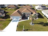 Beautiful single-story home with a well-manicured lawn, large driveway, and a charming front entrance at 5291 Nw 20 Pl, Ocala, FL 34482