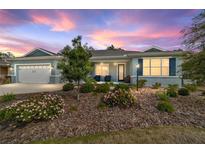 Charming single-story home featuring a three-car garage, covered porch, and landscaped front yard at 10445 Sw 90Th Street Rd, Ocala, FL 34481