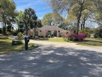 Spacious home with a circular driveway and mature landscaping at 19903 Sw 97Th Ln, Dunnellon, FL 34432