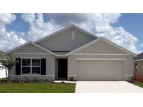 Charming single-story home featuring a two-car garage, neutral stucco, and a well-manicured lawn against a blue sky at 4738 Sw 88Th Ln, Ocala, FL 34476