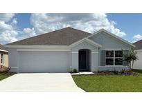 Charming single-story home with a two-car garage, gray exterior, and well-manicured lawn at 4754 Sw 88Th Ln, Ocala, FL 34476