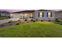 Charming single-story home featuring a manicured lawn, symmetrical landscaping and a two car garage at 8218 Sw 92Nd Cir, Ocala, FL 34481