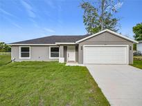 Charming single-story home with a well-manicured lawn and attached two-car garage, offering comfort and convenience at 14914 Se 28Th Ct, Summerfield, FL 34491