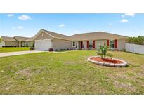 Charming single-story home with a well-manicured lawn, red shutters and a two-car garage at 15470 Sw 34Th Ave, Ocala, FL 34473