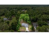 Expansive aerial view shows property, surrounded by lush greenery and mature trees, offering privacy at 5118 Sw 197Th Ter, Dunnellon, FL 34431