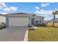 Charming single-story home featuring a two-car garage, manicured lawn, and a welcoming entrance at 9312 Sw 58Th Cir, Ocala, FL 34476