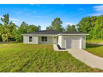 Inviting single-story home featuring a well-manicured lawn and an attached one-car garage at 14390 Sw 30 Pl, Ocala, FL 34481